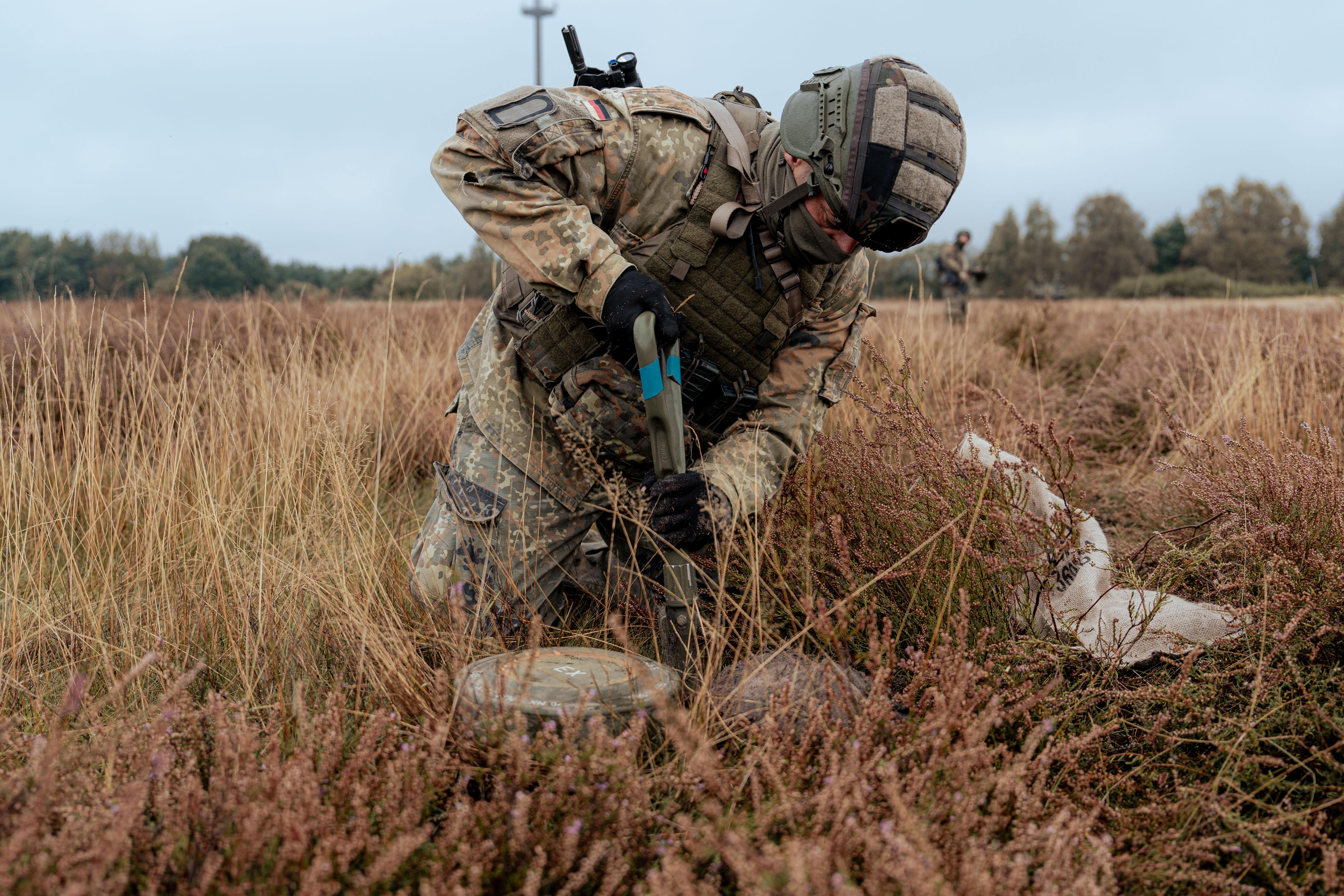 Bundeswehr soldier manually detecting mines in the field
